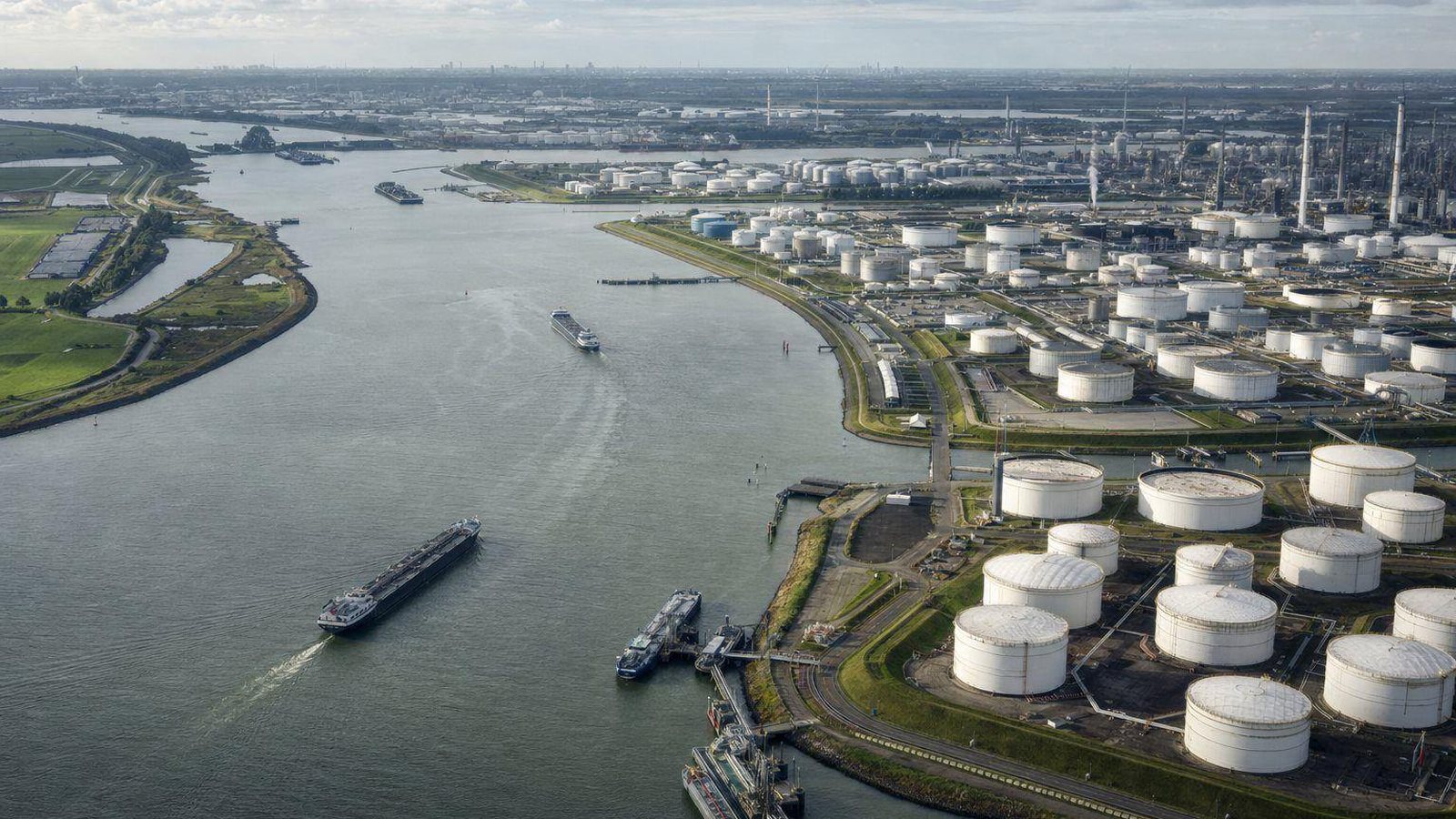 Aerial view of a river port with tank farms and barges in the Amsterdam-Rotterdam-Antwerp region